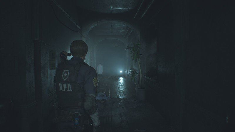 dark hallway with a dead body laying on the ground