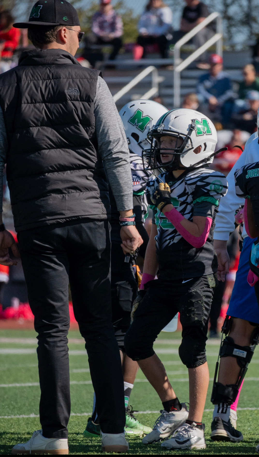 Coaching a 3rd grade youth football team during practice