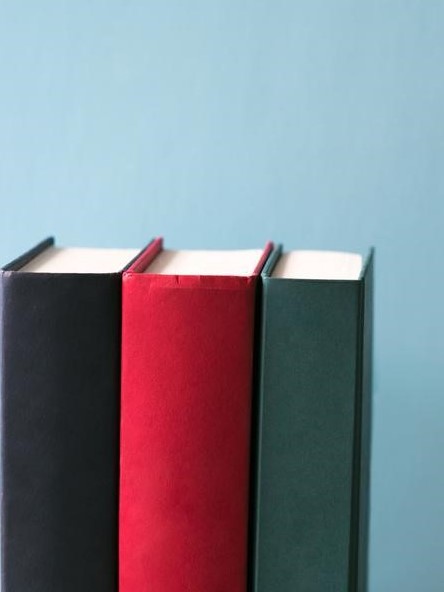 Hard cover books on a blue background.