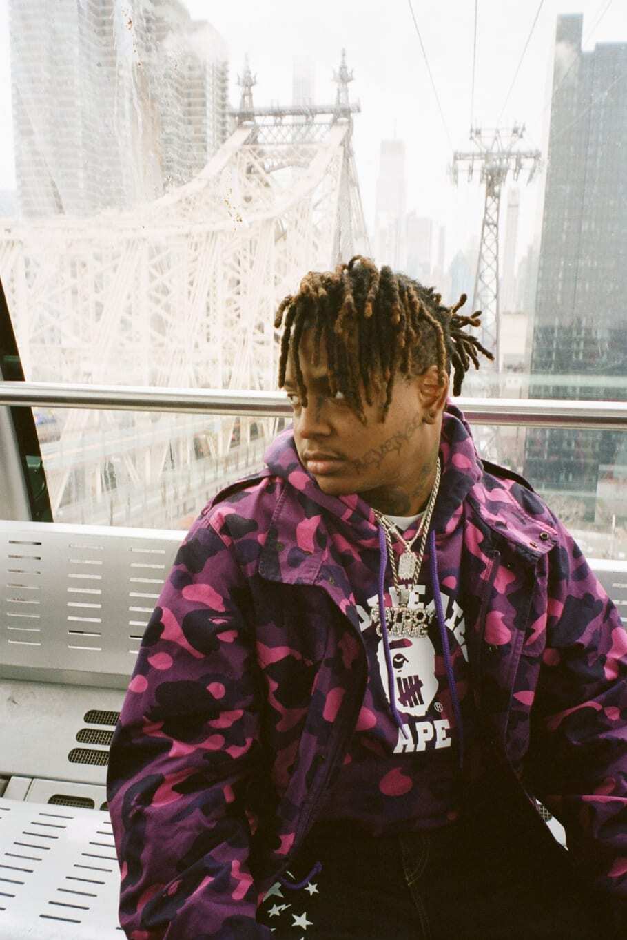 Ski Mask the Slump God wearing purple camo Bape and Undefeated collaboration jacket