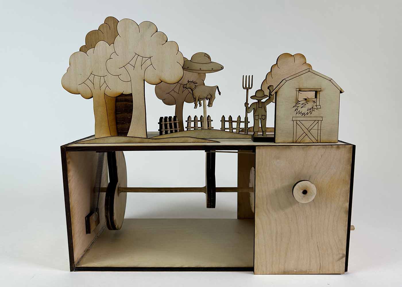 A wooden automata depicting a farmer chasing away a UFO attempting to abduct a cow.