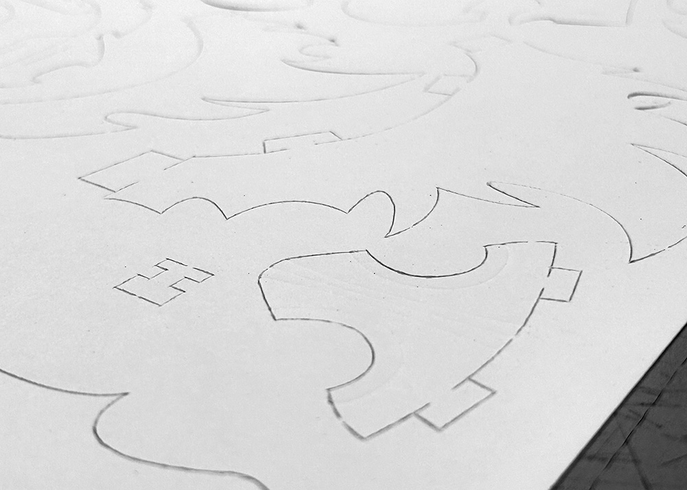A bristol paper sheet with each of the lion mask's pieces cut out.
