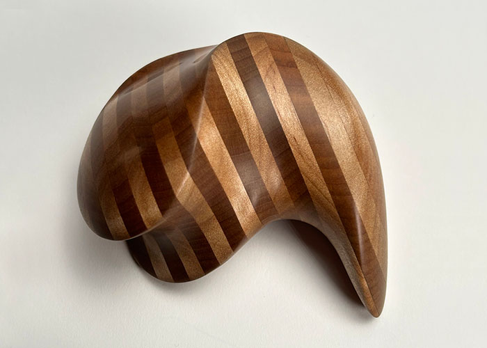 A handheld, striped wooden monolith.