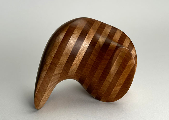 A handheld, striped wooden monolith.
