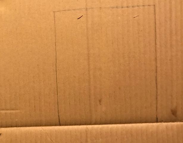 A square door has been penciled onto the cardboard. They definetly used a ruler.